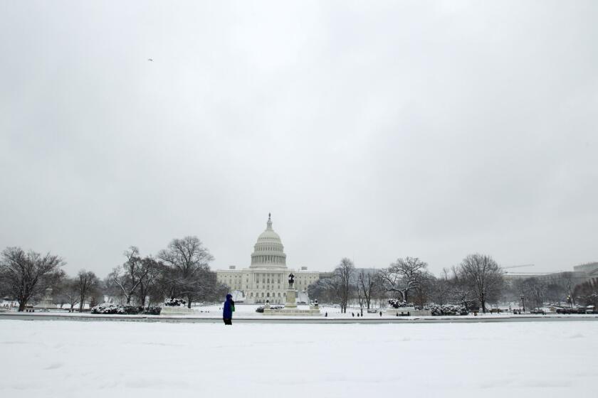 People walk outside of the U.S. Capitol building during a snowstorm, as a partial government shutdown stretches into its third week at Capitol Hill in Washington Sunday, Jan. 13, 2019. With the standoff over paying for his long-promised border wall dragging on, the president's Oval Office address and visit to the Texas border over the past week failed to break the logjam and left aides and allies fearful that the president has misjudged Democratic resolve and is running out of negotiating options. (AP Photo/Jose Luis Magana)