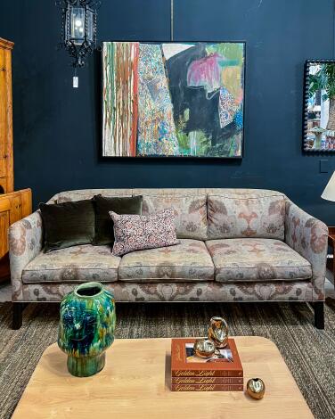 An abstract painting hangs over a sofa in patterned fabric at Nickey Kehoe. 