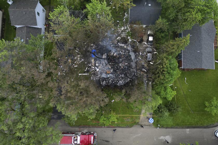 Smoke still rises from the aftermath of a home explosion in unincorporated Lake Zurich, Ill., Wednesday, June 5, 2024. First responders found the home leveled after an explosion about 8:30 p.m. Tuesday in according to the Lake County sheriff's office. (Stacey Wescott/Chicago Tribune via AP)