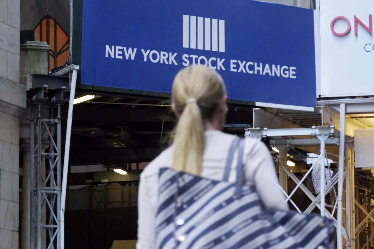 A woman passes an entrance of the New York Stock Exchange.