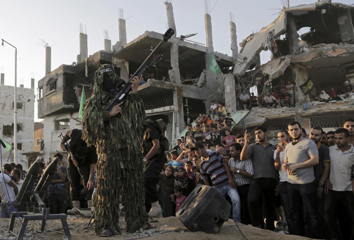 A Palestinian militant from the military wing of Hamas holds a rifle during a celebration amid the debris of destroyed houses in Gaza City on Aug. 27 after a cease-fire was declared with Israel.