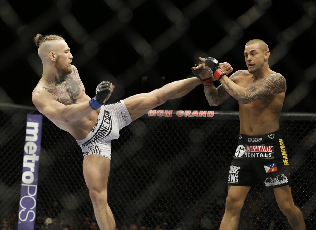 FILE - In this Sept. 27, 2014, file photo, Conor McGregor, left, kicks Dustin Poirier 