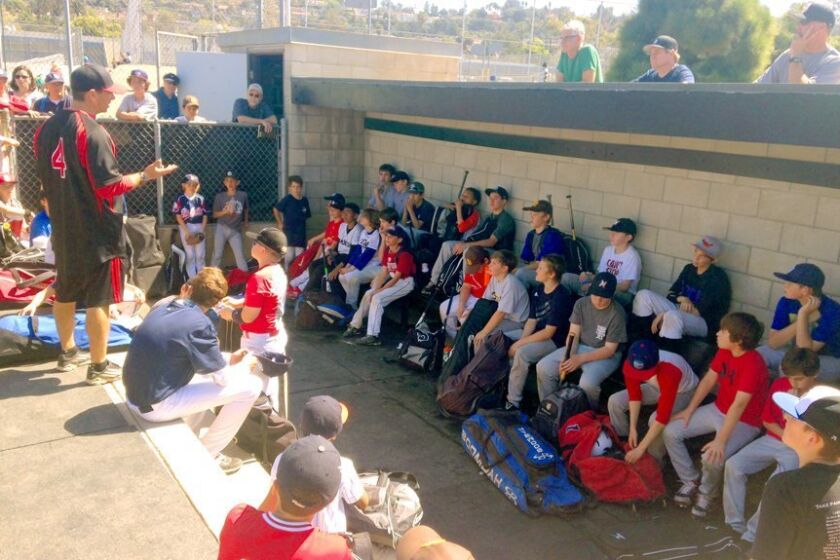 La Jolla High School Vikings head coach Gary Frank (No. 4) addresses la Jolla Youth Baseball players following a 3-hour clinic hosted by the coaches and high school players at Muirlands’ Spelman Field.
