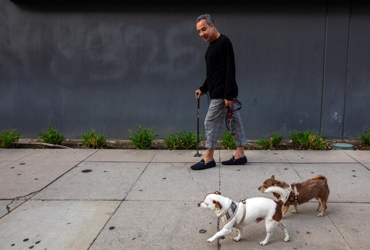 Javier Mejia, 58, is walking his dogs outside the Vagabond Inn near USC in September. 