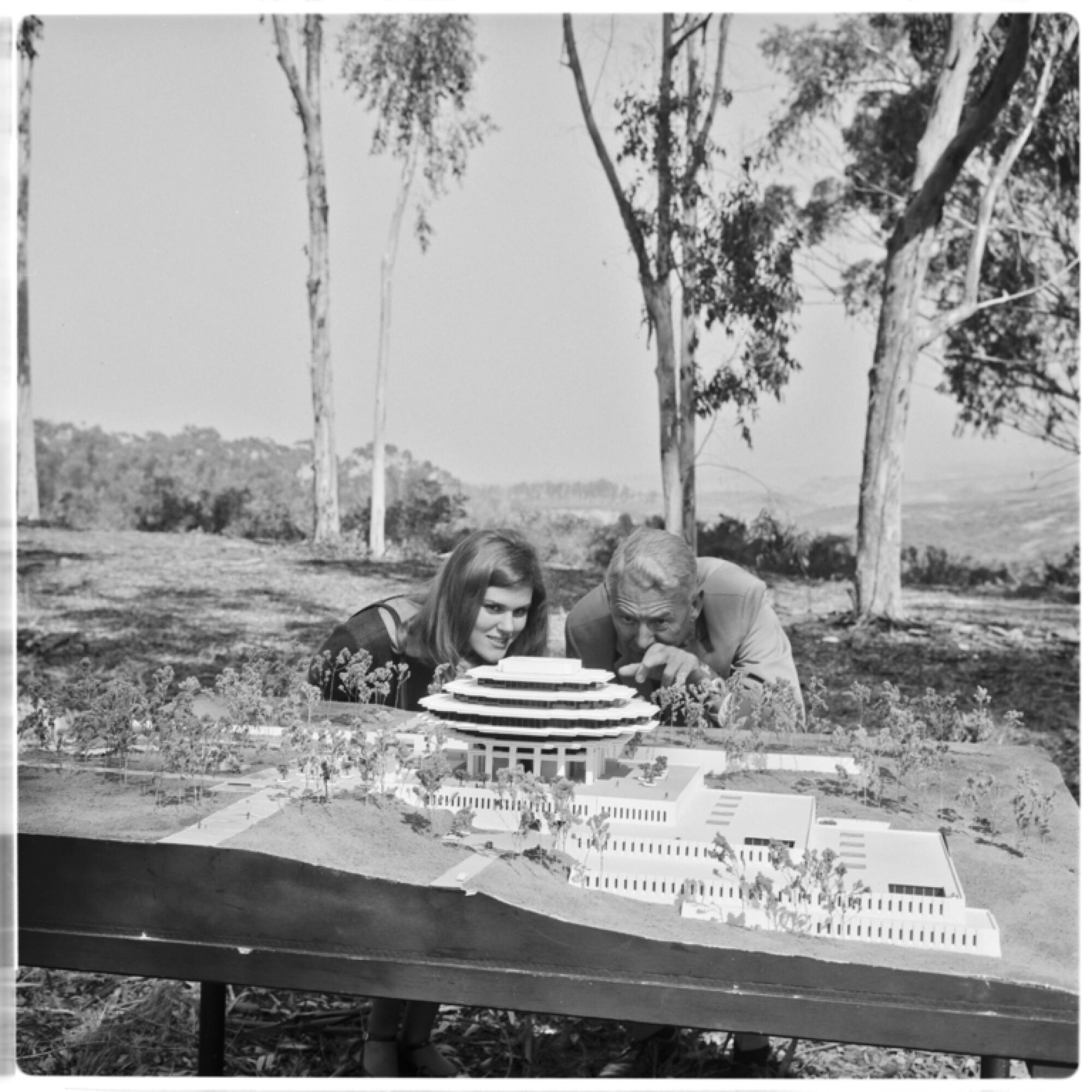 Freshman Valerie Lipiniski and Chancellor John S. Galbraith study model of UCSD's new Central Library in 1967.