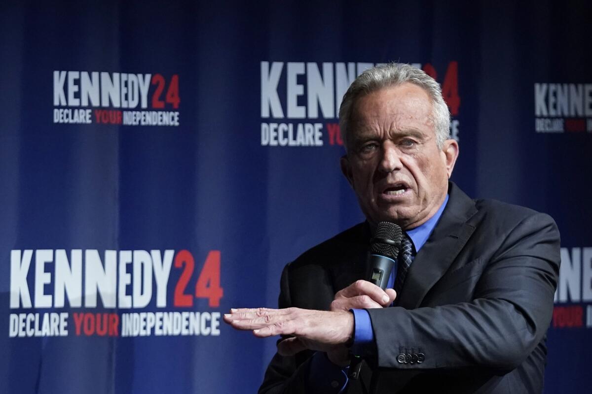 Robert F. Kennedy Jr. speaks before a campaign banner 