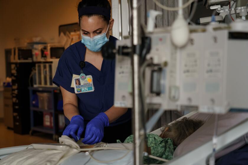 SAN DIEGO, CALIF. -- SATURDAY, APRIL 18, 2020: Registered nurse Erin Jenkins provides care for a patient at UCSD Health in San Diego, Calif., on April 18, 2020. (Marcus Yam / Los Angeles Times)