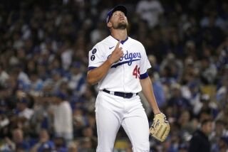 Los Angeles Dodgers relief pitcher Blake Treinen points skyward during the eighth inning