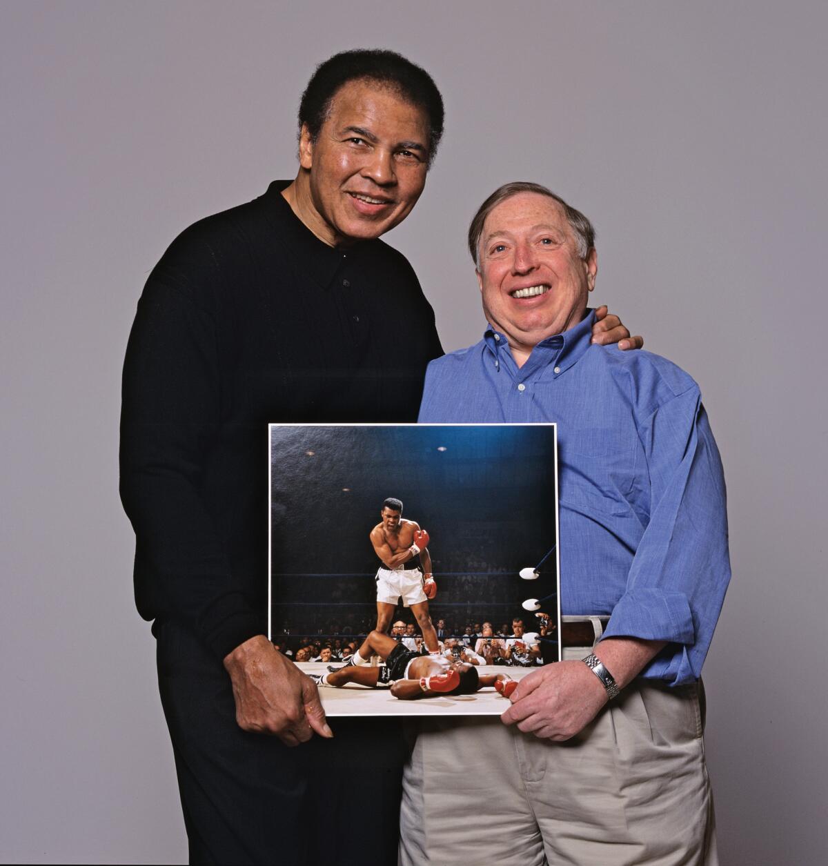 Muhammad Ali and photographer Neil Leifer, holding Leifer's famous photo taken after Ali knocked out Sonny Liston. The image is taken from Leifer's new book, "Relentless." (Neil Leifer)