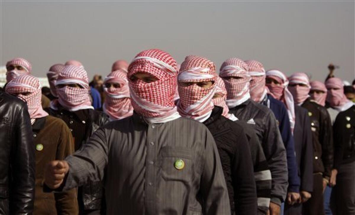 In this Thursday, Jan. 24, 2013 photo, masked men parade during a protest against Iraq's Shiite-led government in Ramadi, 70 miles (115 kilometers) west of Baghdad, Iraq. Iraqi insurgents are trying to capitalize on the rage of anti-government protesters and the instability caused by rising civil unrest, complicating the government’s efforts to stamp out a resurgent al-Qaida and other extremists. (AP Photo/ Khalid Mohammed)