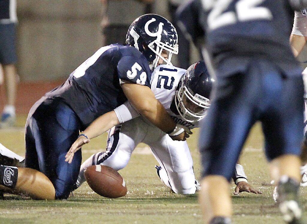 Newport Harbor High quarterback Cole Norris loses the ball as he is hit by Trabuco Hills defensive lineman David Stobbe in first half that resulted in a touchdown for Trabuco on Friday.