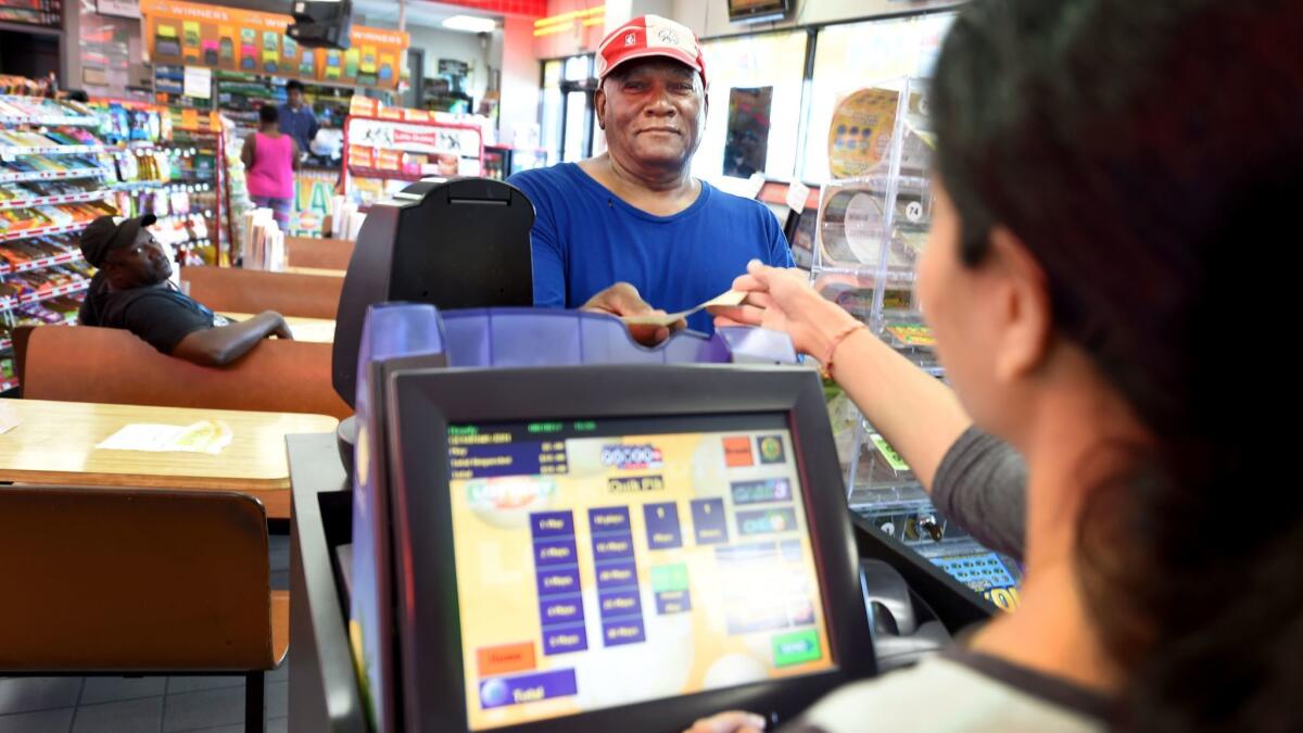 Bowler Samuels buys a Powerball ticket for Saturday's drawing at Bodie's convenience store in Augusta, Ga.