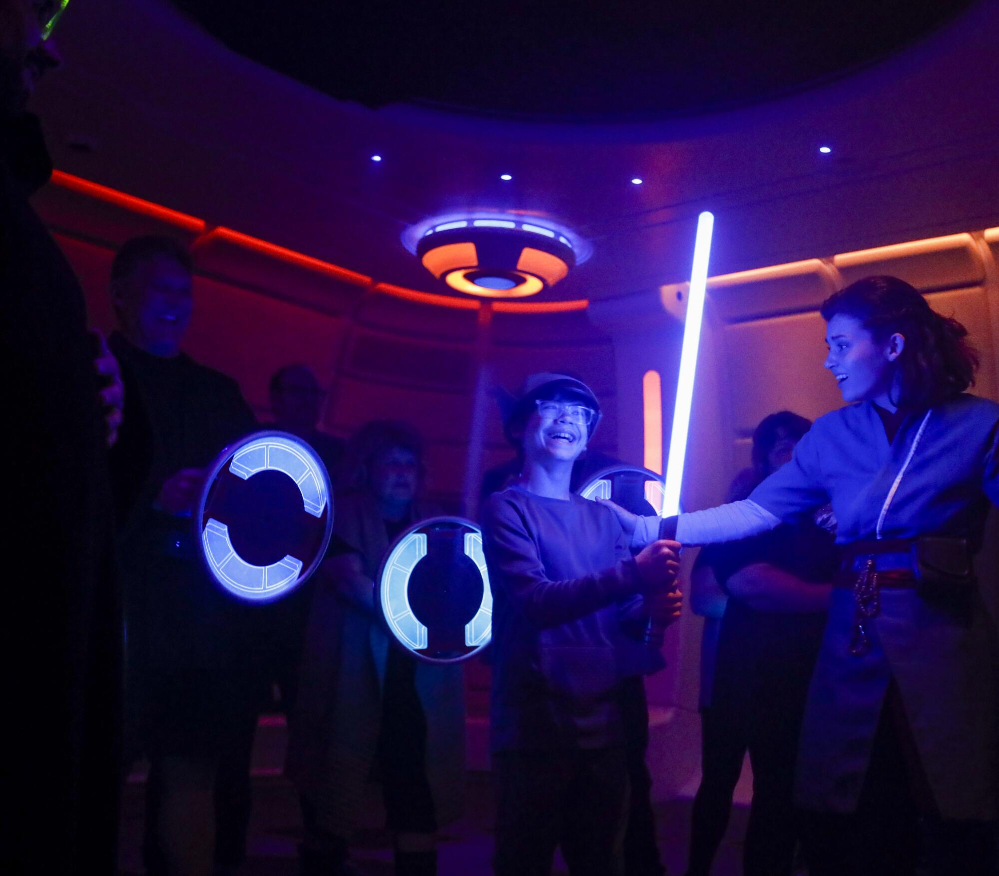 Andrew Stapleton receives light saber training from the Saja.