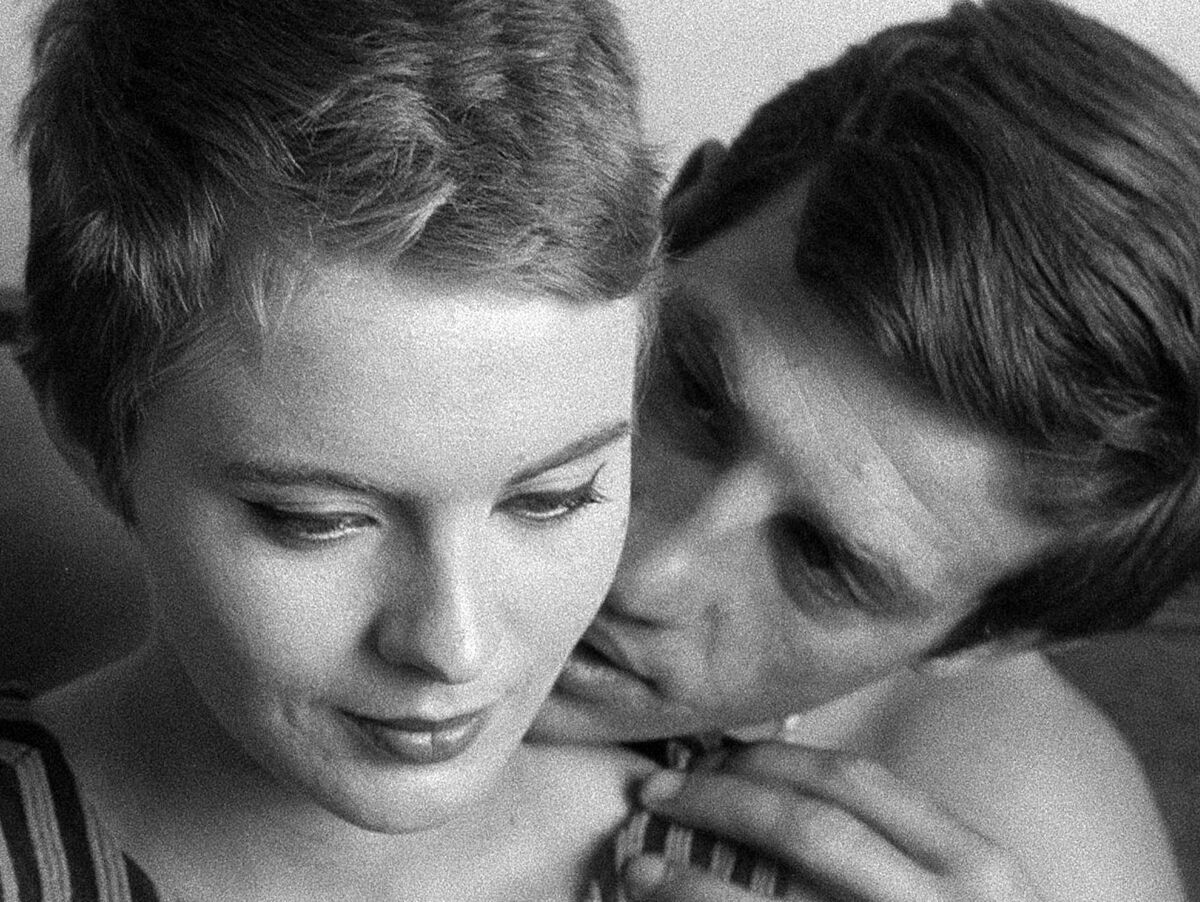 A man rests his chin on a young woman's shoulder in the movie "Breathless."