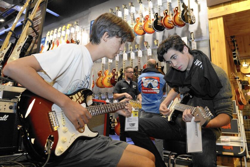 From left, Jack Woods and Nate Aldin jam during the opening of Guitar Center's Westlake Village store.