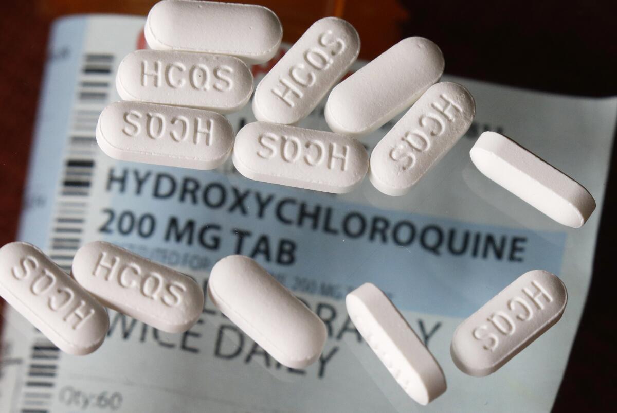 Hydroxychloroquine pills are arranged on top of a prescription label. 
