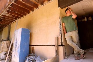 Denny Jaconi standing next a damaged portion of his home caused by the ongoing landslide.