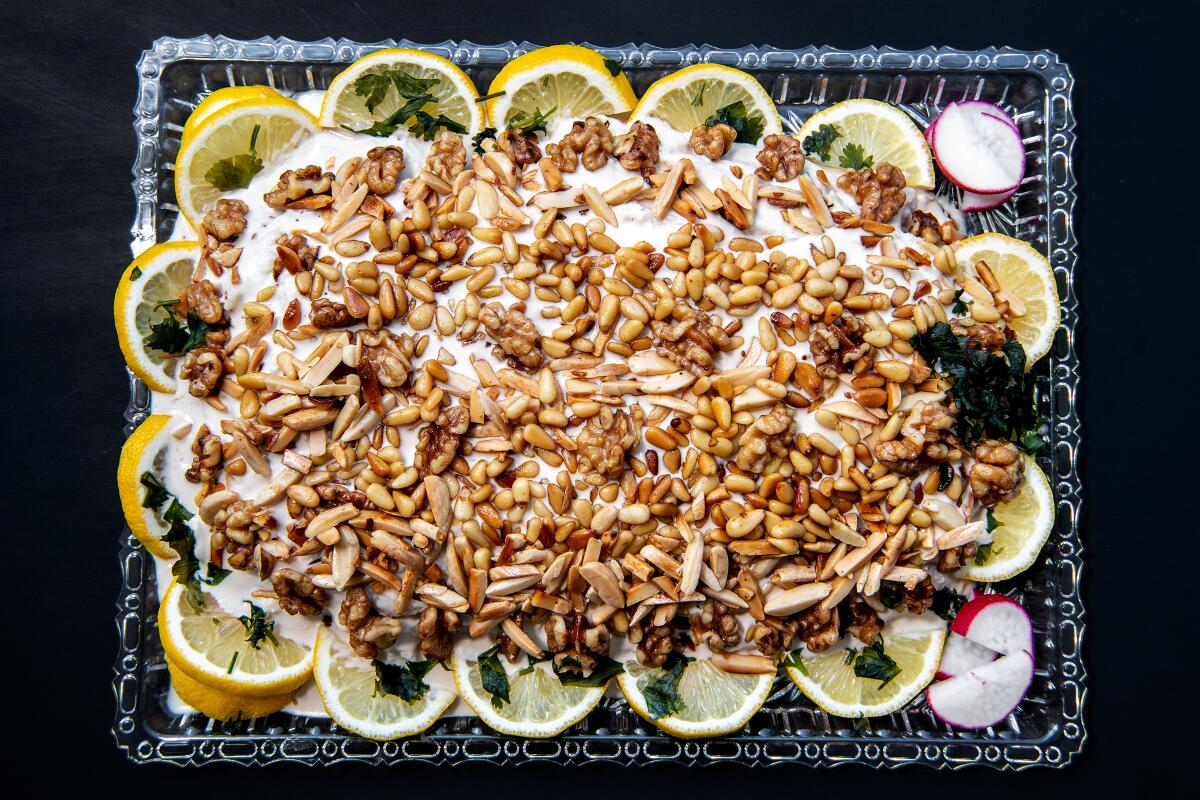 Swai fish stuffed with spices and crushed walnuts, covered with tahini sauce and topped with toasted pine nuts and walnuts