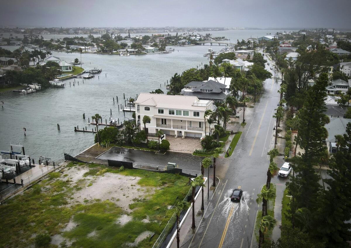 A driver negotiates a flooded street as Tropical Storm Debby passes just to the west of the Tampa Bay.