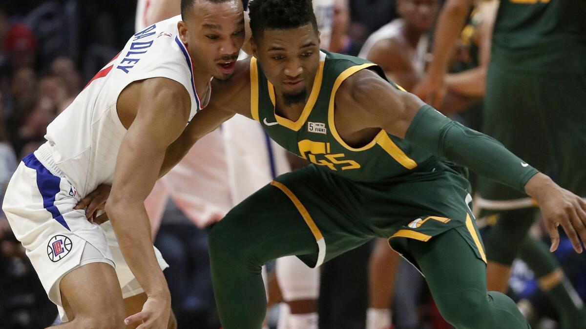 Clippers guard Avery Bradley slaps the ball away from Utah Jazz guard Donovan Mitchell in the second quarter on Wednesday at Staples Center.