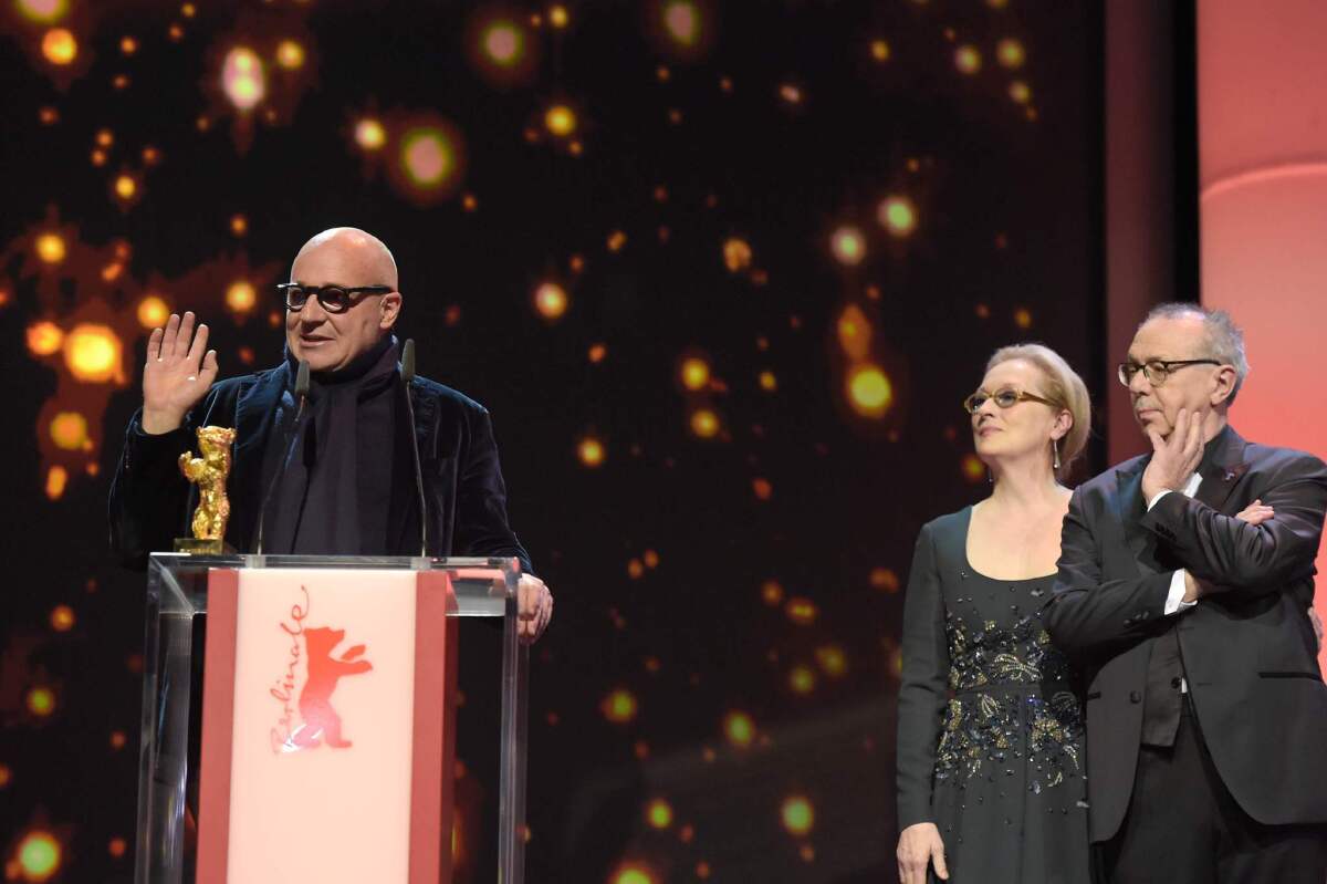 Italian director Gianfranco Rosi accepts his Golden Bear Award with actress and jury President Meryl Streep and Berlinale festival director Dieter Kosslick.