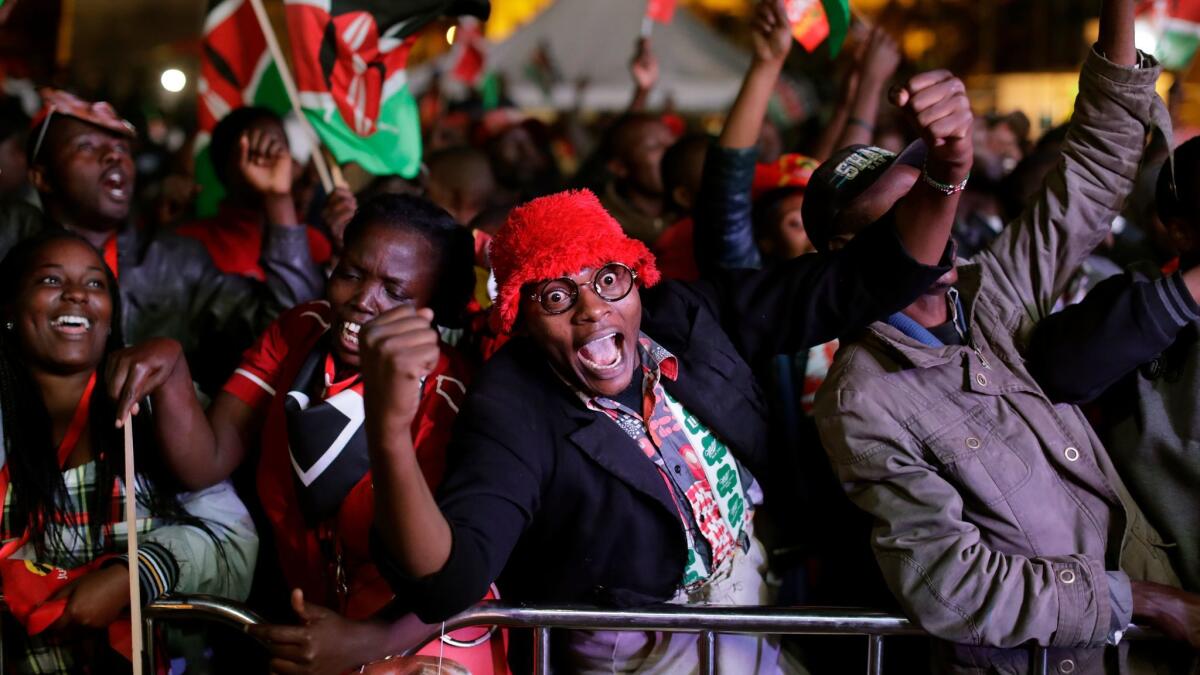 Supporters of President Uhuru Kenyatta erupt in cheers at the Kenya International Conference Center in Nairobi after hearing that his has won a second term.