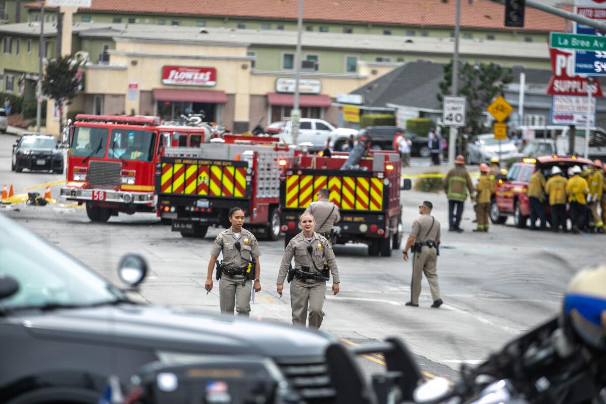 CHP officers walk next to emergency vehicles