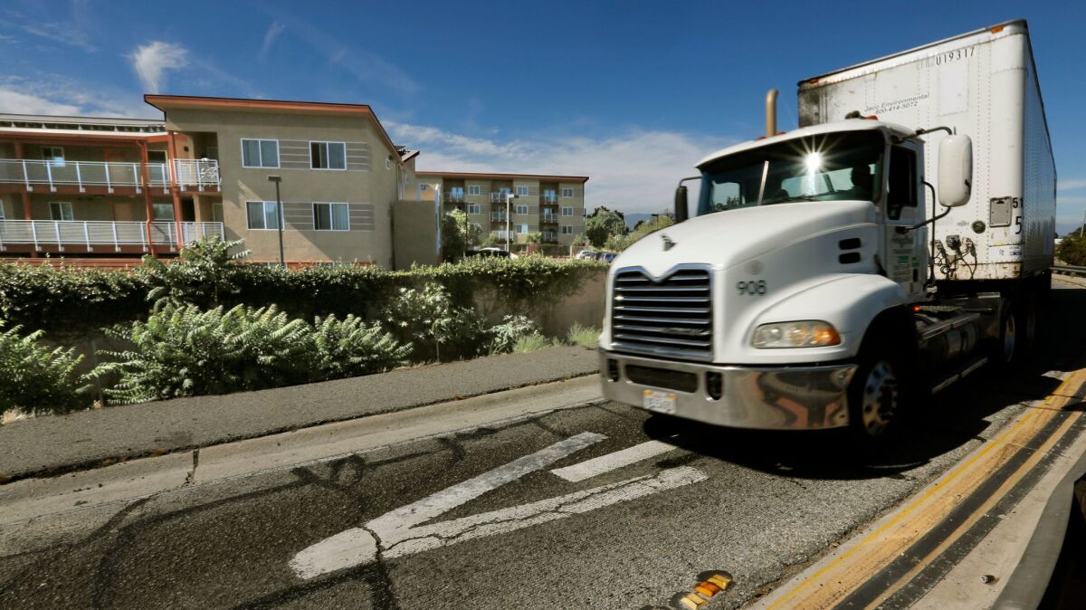 A truck exits the 710 Freeway next to an apartment complex at East Alondra Boulevard in Compton.