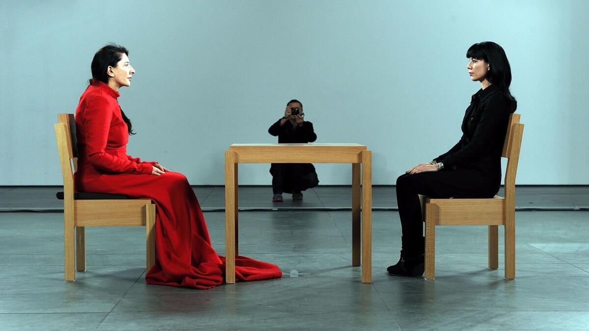 Artist Marina Abramovic, left, performs during "Marina Abramovic: The Artist Is Present" exhibition at the Museum of Modern Art in 2010.