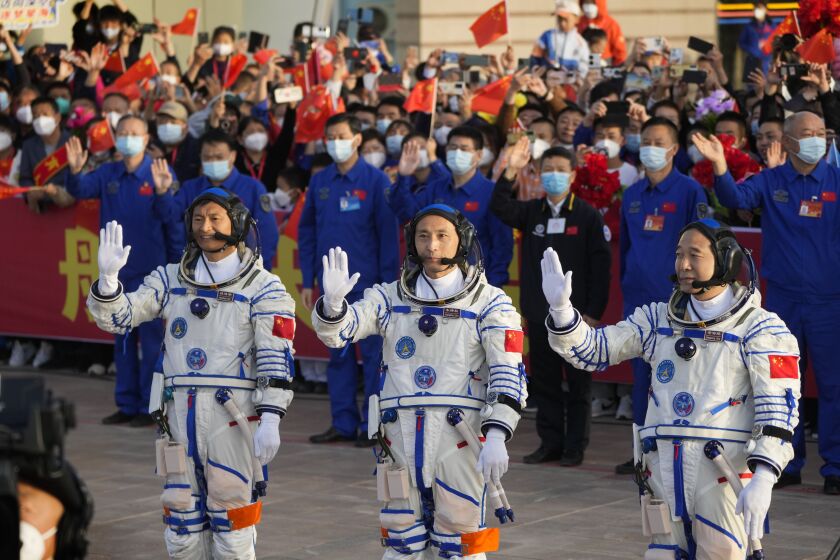 Chinese astronauts for the Shenzhou-16 mission, from left, Gui Haichao, Zhu Yangzhu and Jing Haipeng wave as they attend a send-off ceremony ahead of their manned space mission at the Jiuquan Satellite Launch Center in northwestern China, Tuesday, May 30, 2023. (AP Photo/Mark Schiefelbein)