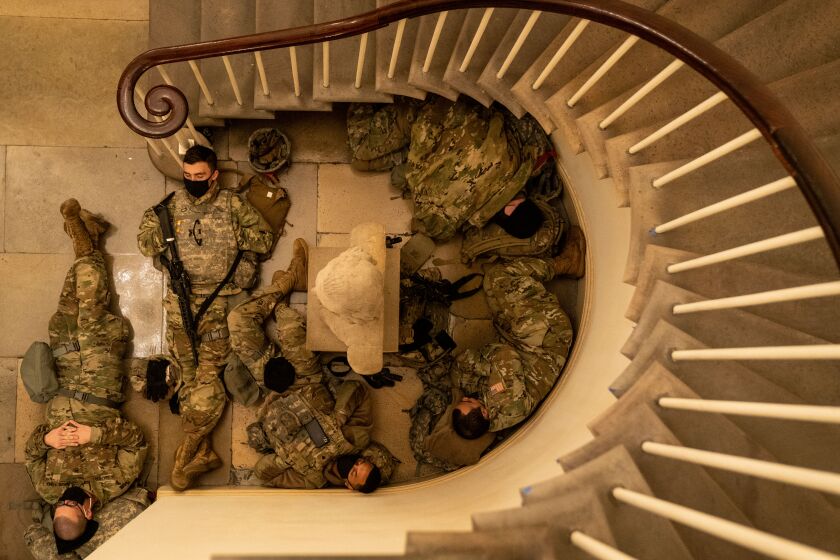 WASHINGTON, DC - JANUARY 13: Members of the National Guard sleep in the halls of Capitol Hill as the House of Representativs convene to impeach President Donald Trump, nearly a week after a pro-Trump insurrectionist mob breached the security of the nation's capitol while Congress voted to certify the 2020 Election Results on Wednesday, Jan. 13, 2021 in Washington, DC. (Kent Nishimura / Los Angeles Times)