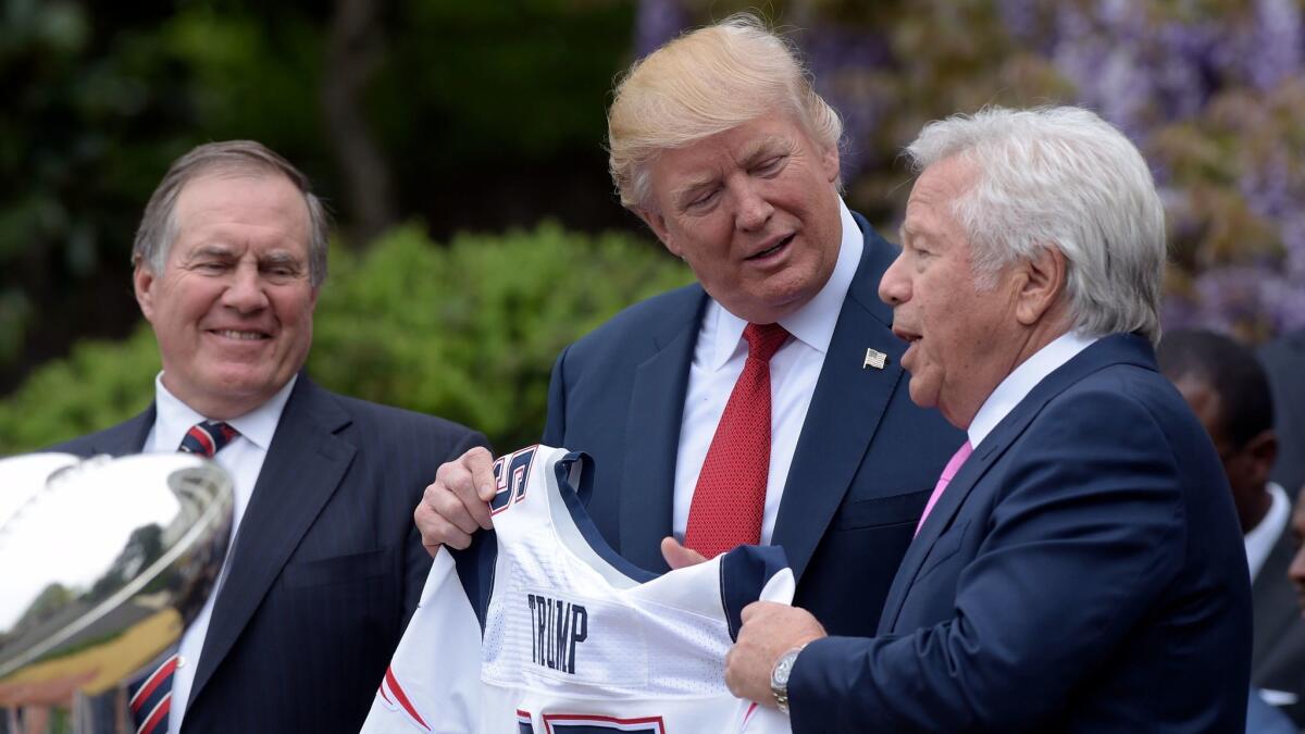 Who's in charge here? President Trump receives a New England Patriots jersey from Patriots owner Robert Kraft, right, and head coach Bill Belichick during a White House ceremony in April.