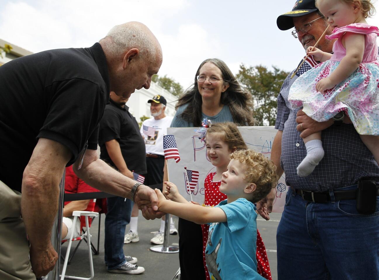 A youngster greets Larry Chesley, left, 74, of Queen Creek, Ariz., a fighter pilot who was a prisoner of war in Vietnam for seven years.