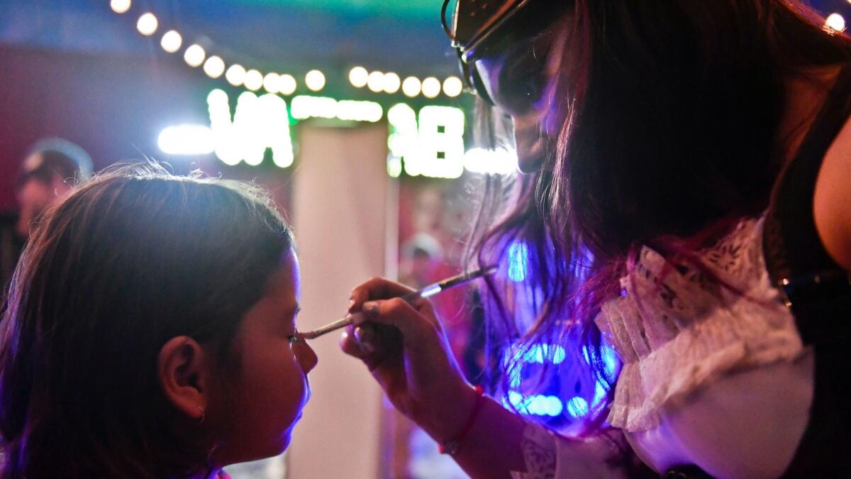 Sidni Politzer, 5, left, has her face painted by Annabel Bachliyski at intermission during a Sunday evening show at Circus Vargas. Bachliyski is also a performer for Circus Vargas.