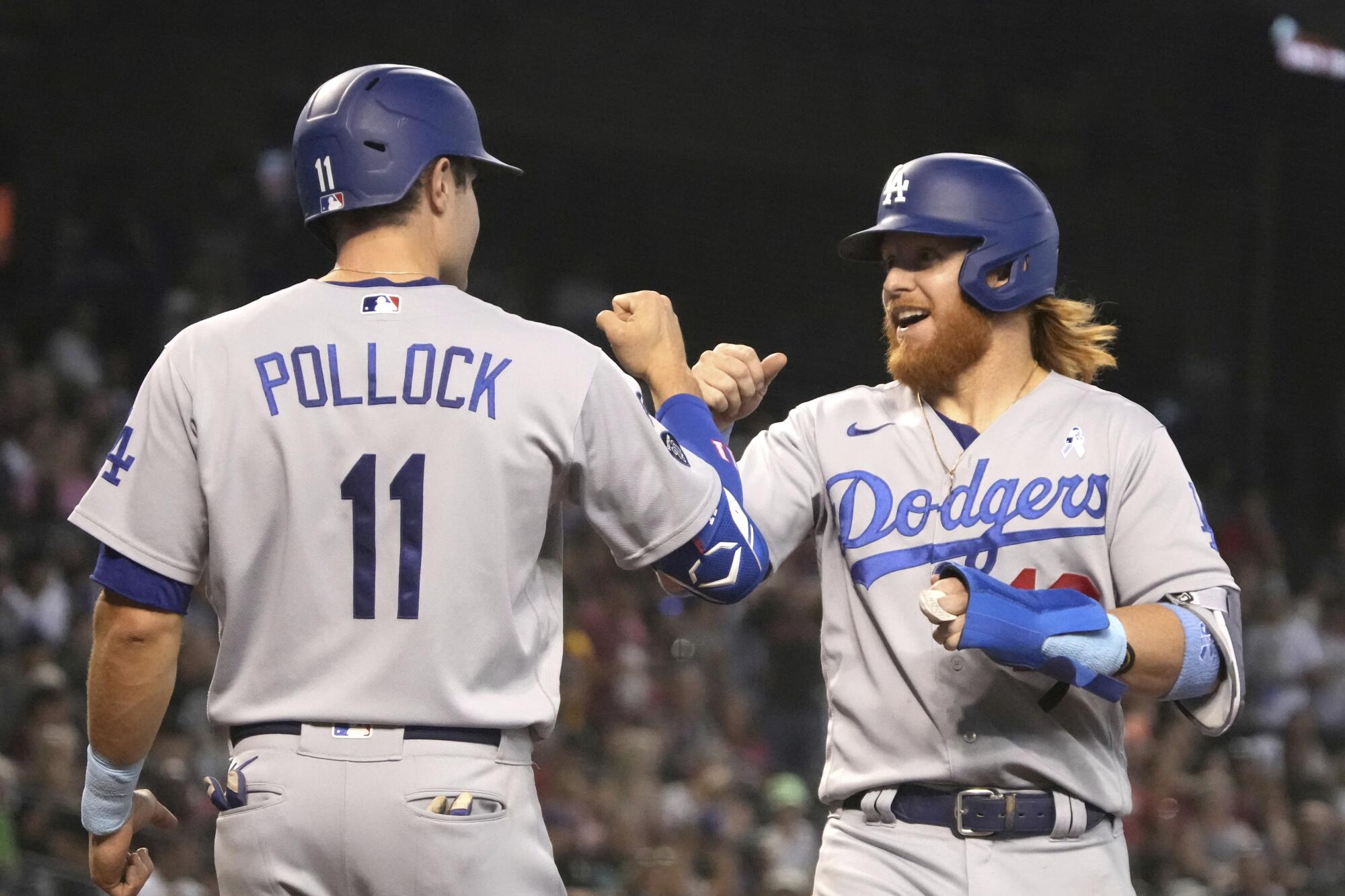 AJ Pollock and Justin Turner celebrate after scoring runs on a home run hit by Albert Pujols.