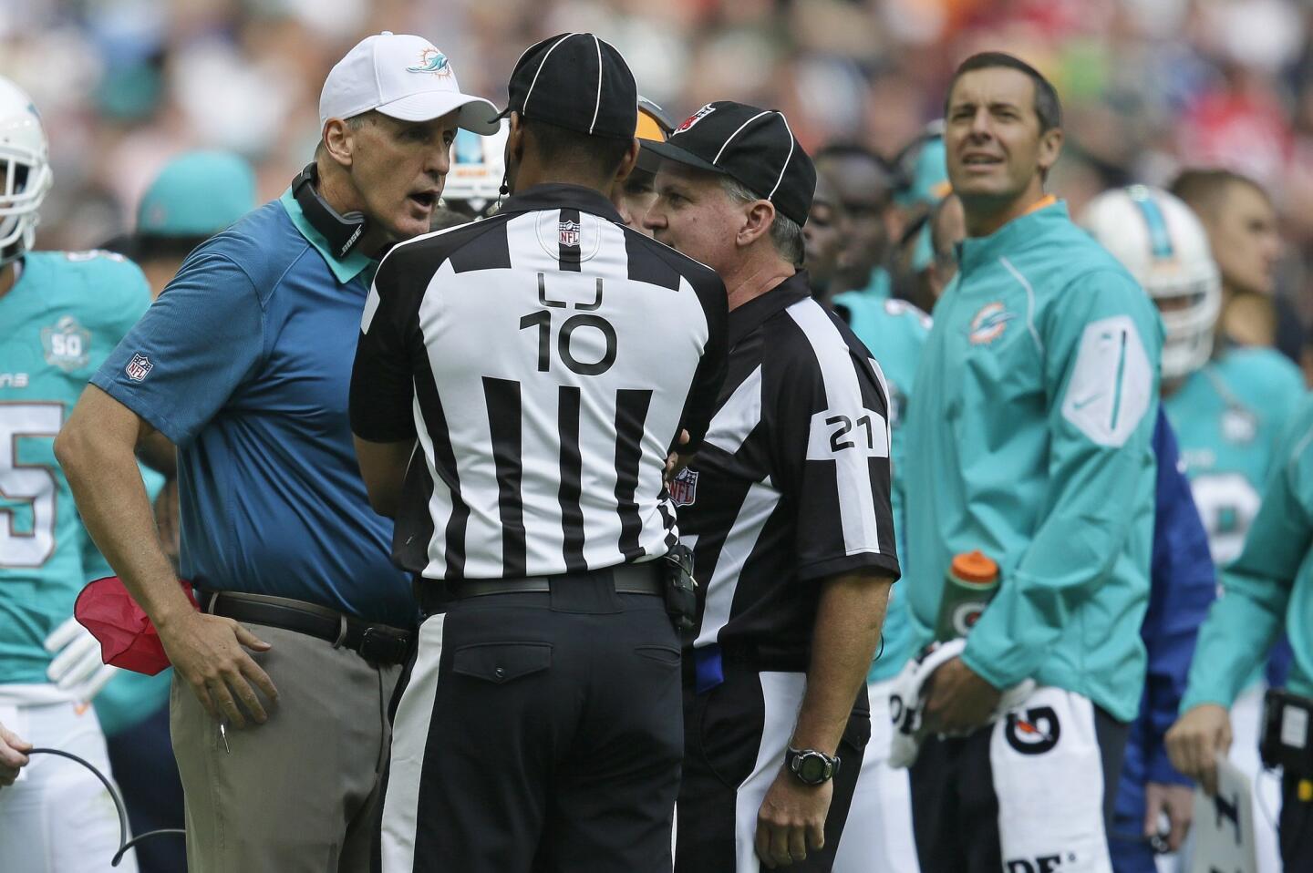 Miami Dolphins head coach Joe Philbin, left, speaks to officials during the NFL football game between the New York Jets and the Miami Dolphins and at Wembley stadium in London, Sunday, Oct. 4, 2015. (AP Photo/Tim Ireland) ORG XMIT: WEM141