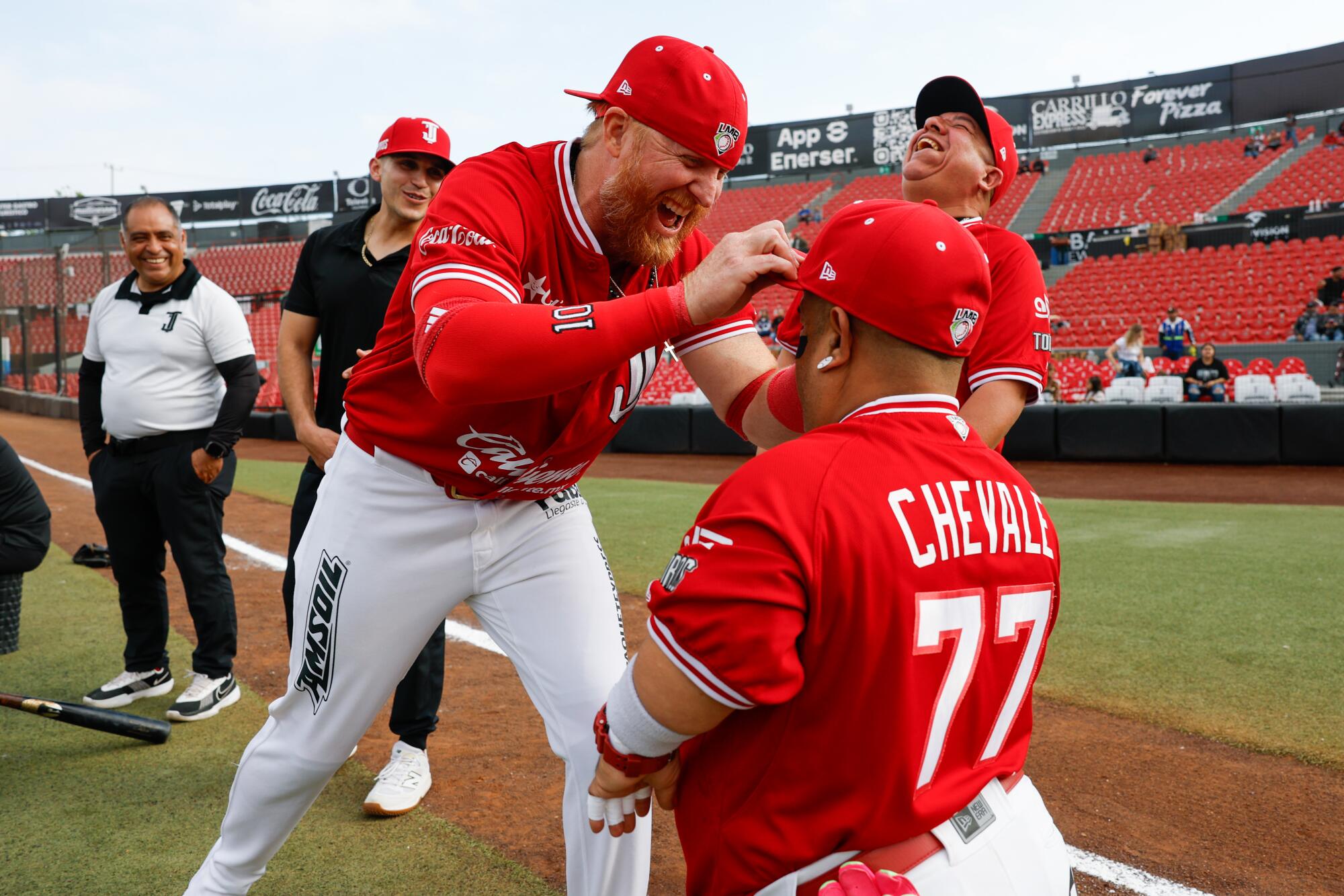 Justin Turner jokes with batboy Valentin "Chevale" Burgos before the start of Saturday's Tijuana Toros game.
