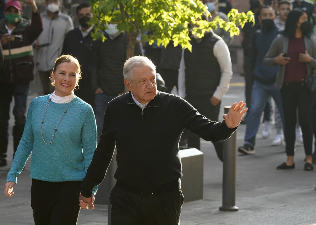 Mexican President Andrés Manuel López Obrador walks with his wife, Beatriz Gutierrez Muller.