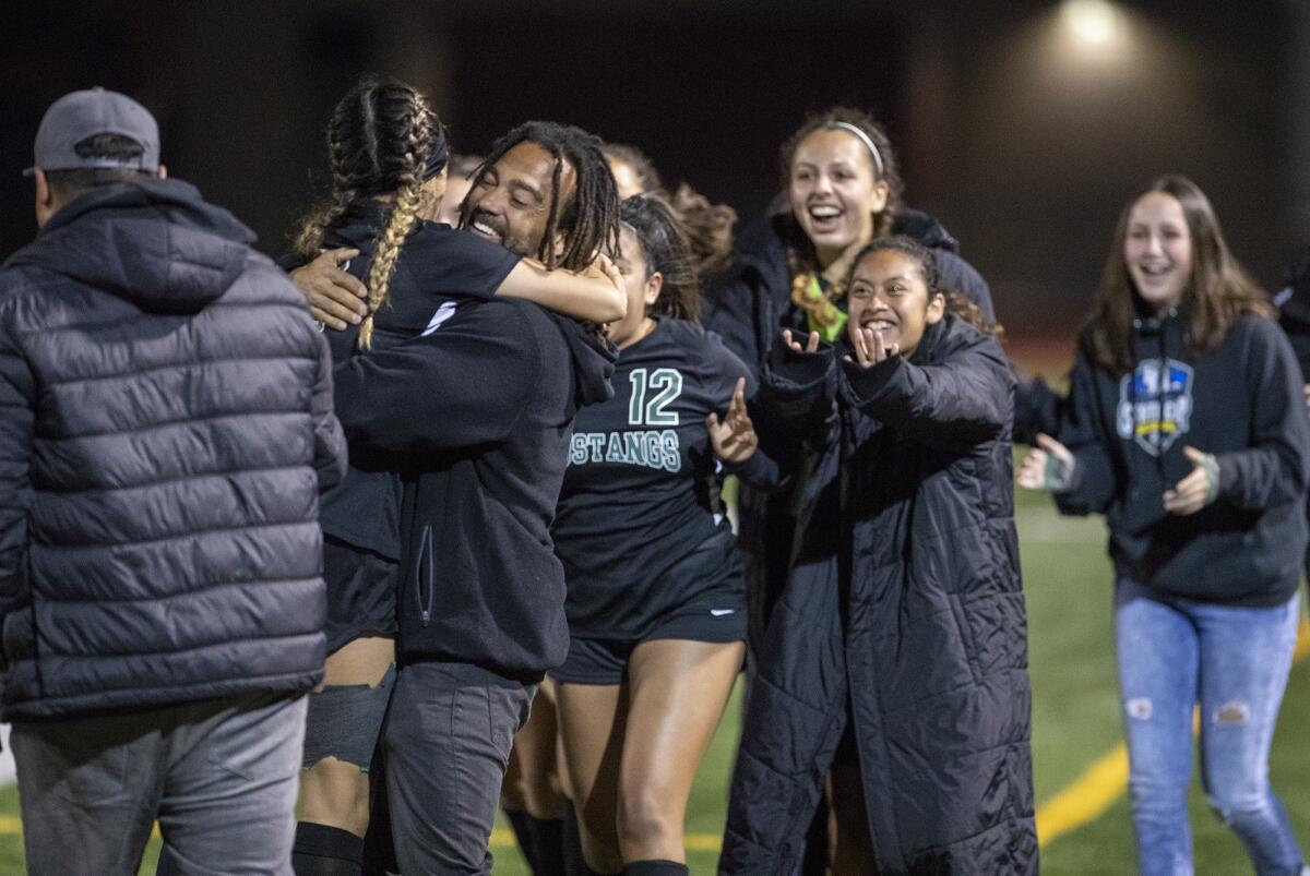 Costa Mesa High coach Jason Boyce hugs Natalia Guzman after she scored the game-winning goal against Hillcrest in the quarterfinals of the CIF Southern Section Division 5 playoffs on Tuesday.