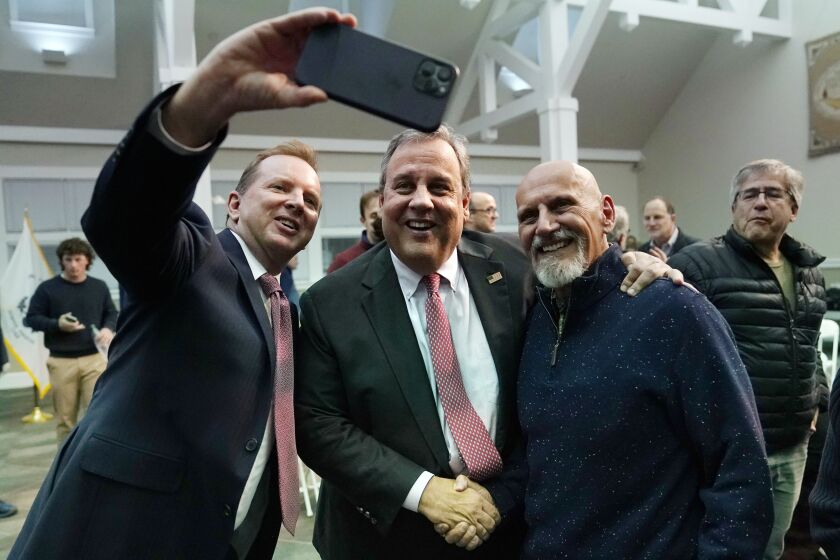 Former New Jersey Gov. Chris Christie, center, poses for a selfie after a town hall style meeting at New England College, April 20, 2023, in Henniker, N.H. Christie is set to launch his campaign for the White House at a town hall in New Hampshire on June 6. He's cast himself as the only candidate willing to directly take on former President Donald Trump.(AP Photo/Charles Krupa)