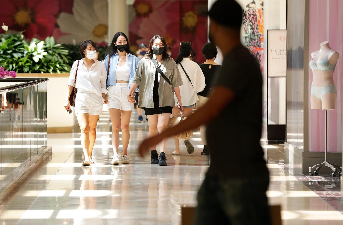 Shoppers wear masks in an indoor mall.