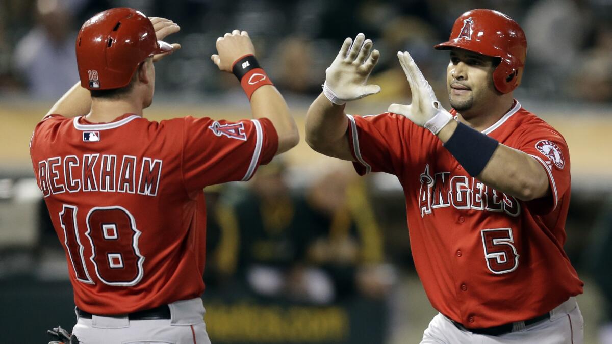 Angels first baseman Albert Pujols, right, celebrates with teammate Gordon Beckham after hitting a three-run home run against the Oakland Athletics on Sept. 22. This season's Angels team has drawn comparisons to the 2002 World Series winning squad.