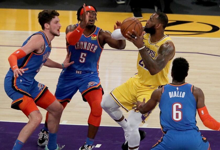 Lakers forward LeBron James goes to the basket against a trio of Oklahoma City Thunder defenders.