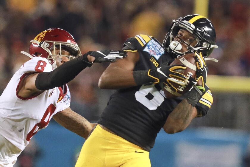 Iowa wide receiver Ihmir Smith-Marsette catches a long pass in front of USC cornerback Chris Steele.