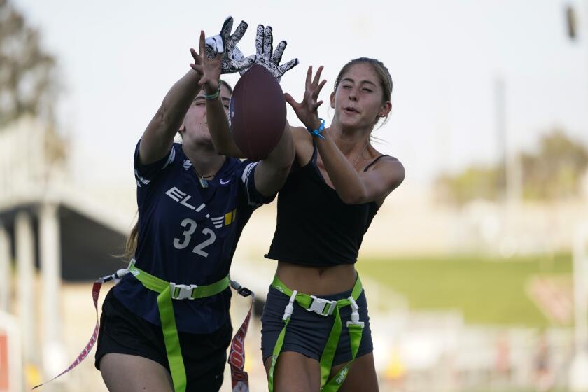 FILE - Aly Young, 17, left, and Shale Harris, 15, reach to catch a pass as they try out for the Redondo Union High School girls flag football team on Thursday, Sept. 1, 2022, in Redondo Beach, Calif. California officials are expected to vote Friday on the proposal to make flag football a girls' high school sport for the 2023-24 school year. (AP Photo/Ashley Landis, File)