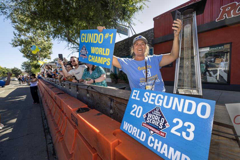 El Segundo, CA - August 28: Hundreds of El Segundo community members line Main Street with signs and cheers as the El Segundo Little League All Stars arrive home to celebrate winning the Little League World Series in El Segundo Monday, Aug. 28, 2023. (Allen J. Schaben / Los Angeles Times)