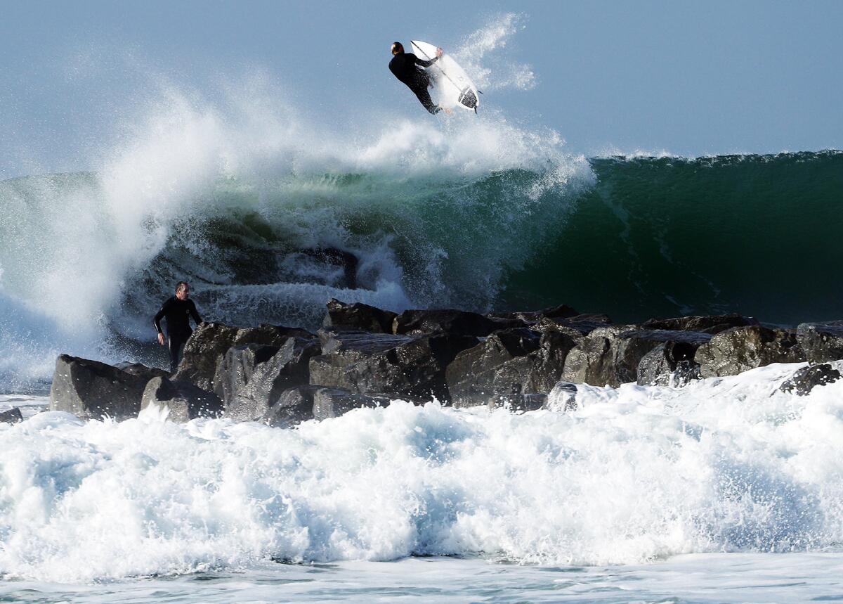 A surfer launches off a monster wave produced by a large storm system.