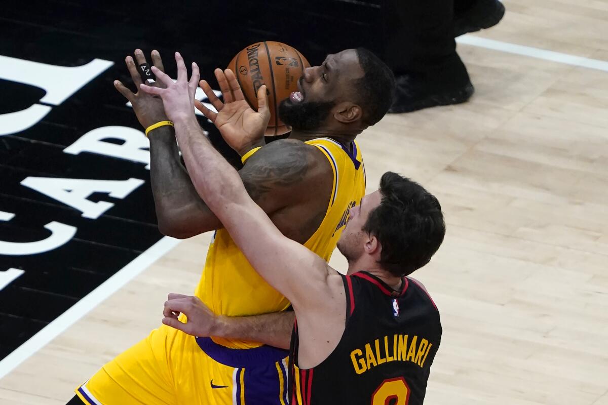 Lakers forward LeBron James is fouled by Hawks forward Danilo Gallinari on a drive to the basket.