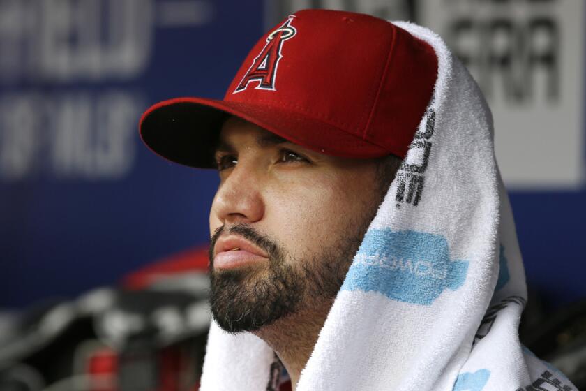 Angels starting pitcher Hector Santiago sits in the dugout during the second inning against the Texas Rangers on Wednesday.