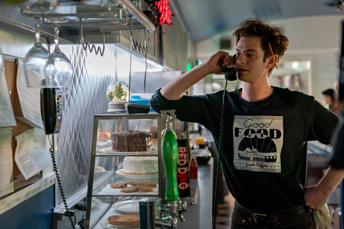 Andrew Garfield answering a phone in a diner